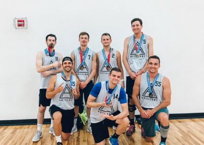 Jake Kramer kneels front left with the ARTILLERY basketball team, medals on from the Cornhusker State Games.