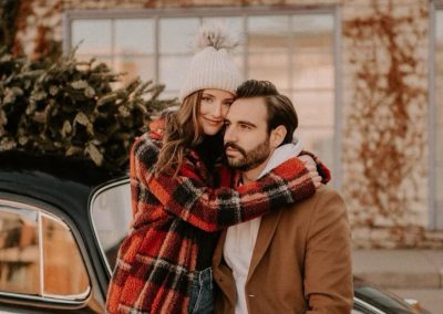 Jake Kramer and his wife with a Christmas tree strapped to the roof of a vintage Beetle.